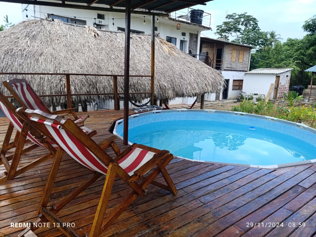 Deck de madera con piscina y sillas de rayas