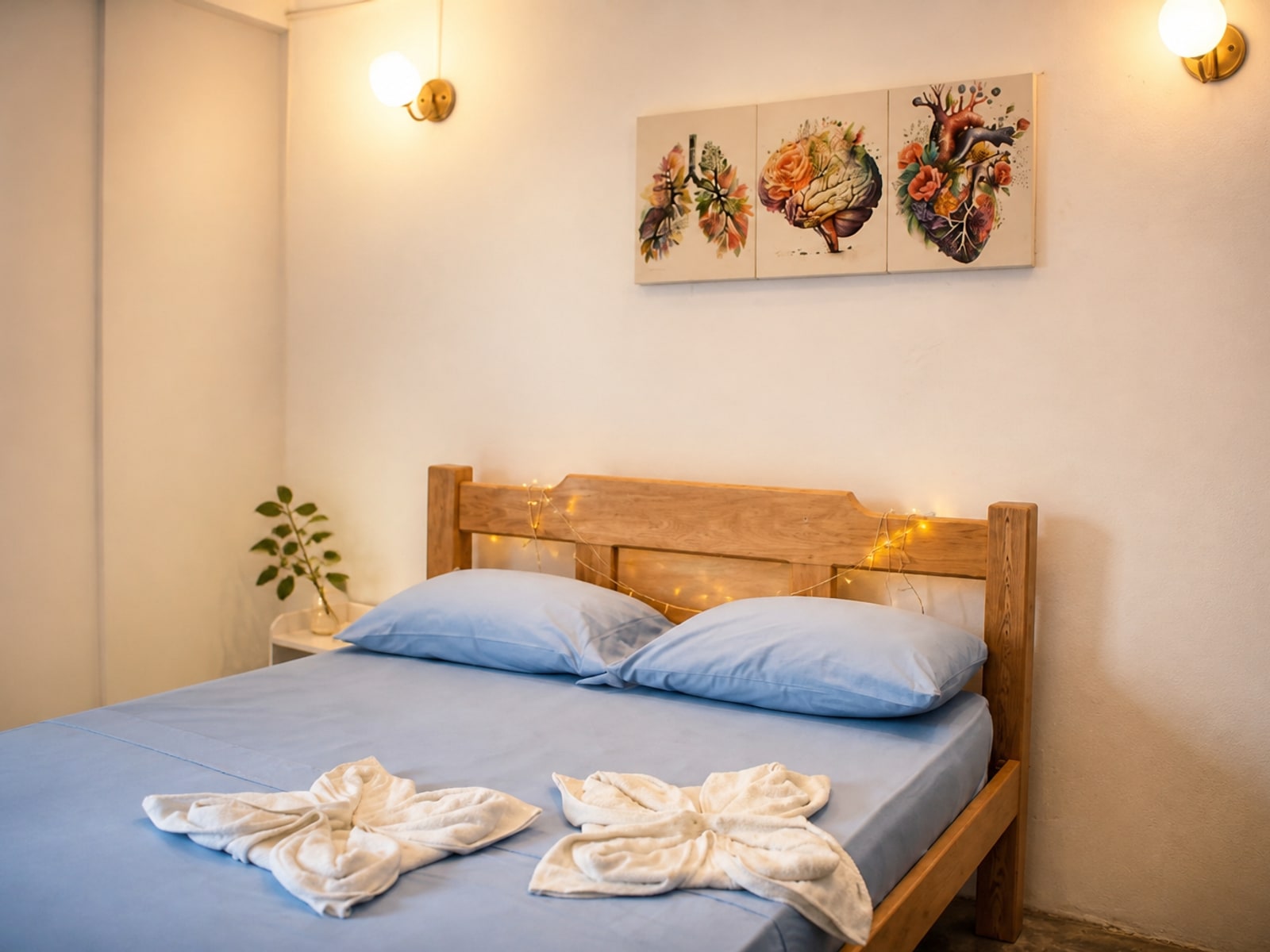 Habitación doble con cama de madera, ropa de cama azul y detalles decorativos